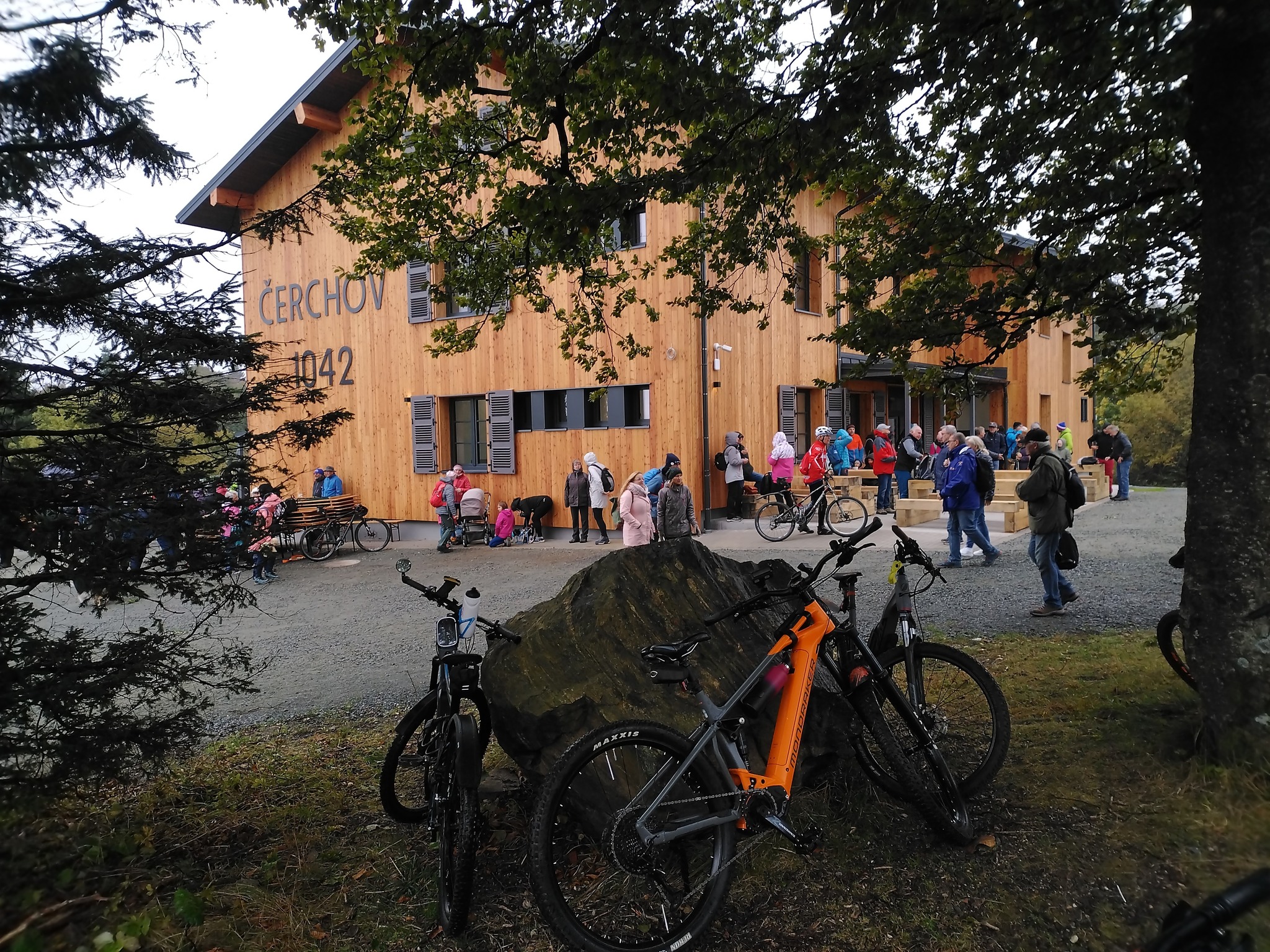 horská chata, v popředí lidé a kola