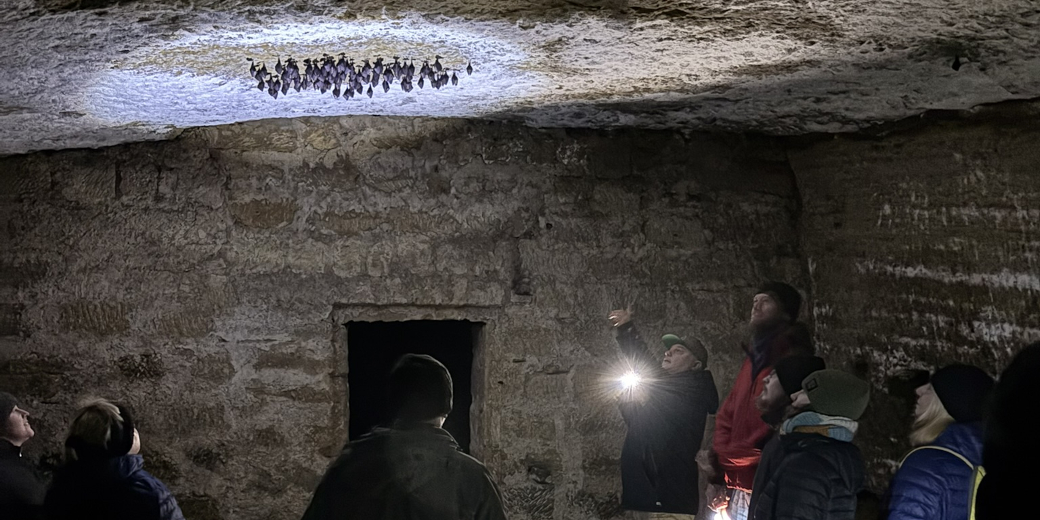 Majitel hájenky ukazuje účastníkům zimující vrápence.